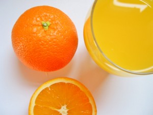 Mandarinas junto a un vaso de zumo de mandarina