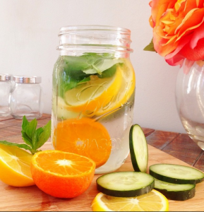 Recipente con rodajas de frutas y agua para preparar agua detox.