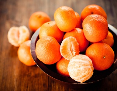 Mandarinas en un cuenco sobre una mesa de madera